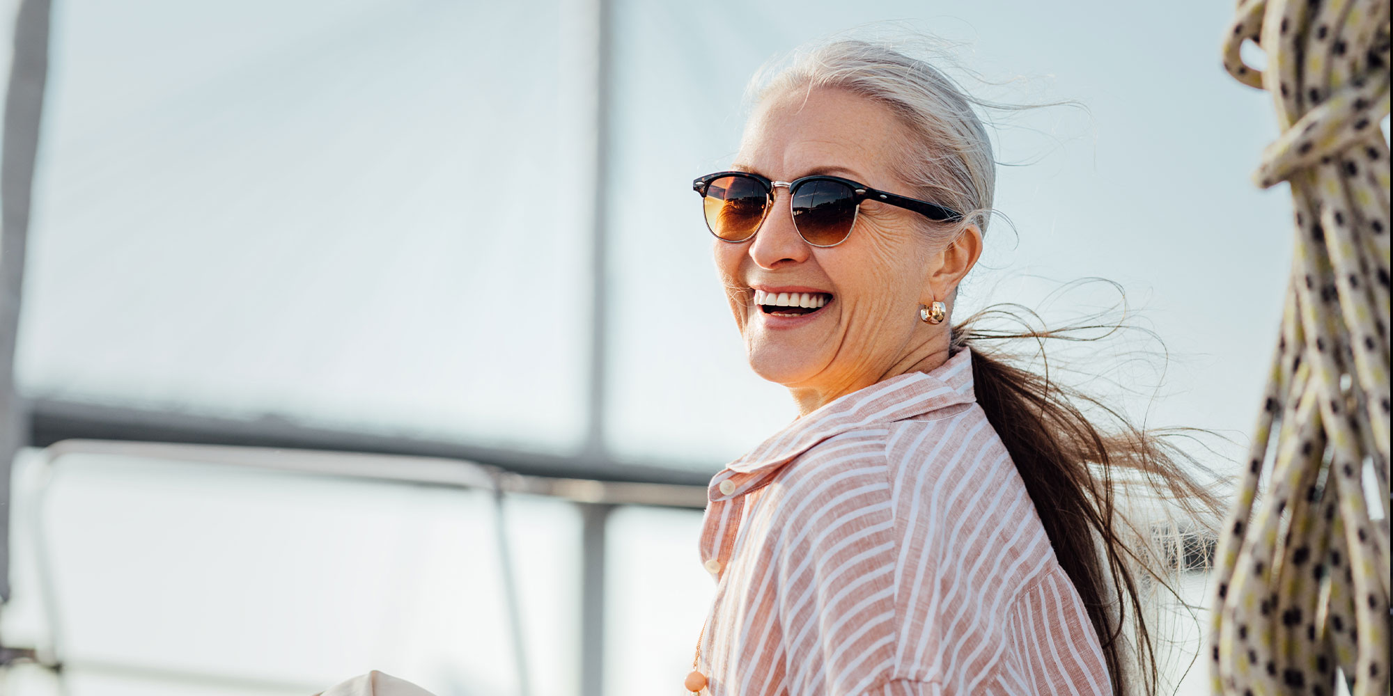 Laughing mature woman wearing sunglasses and looking at camera
