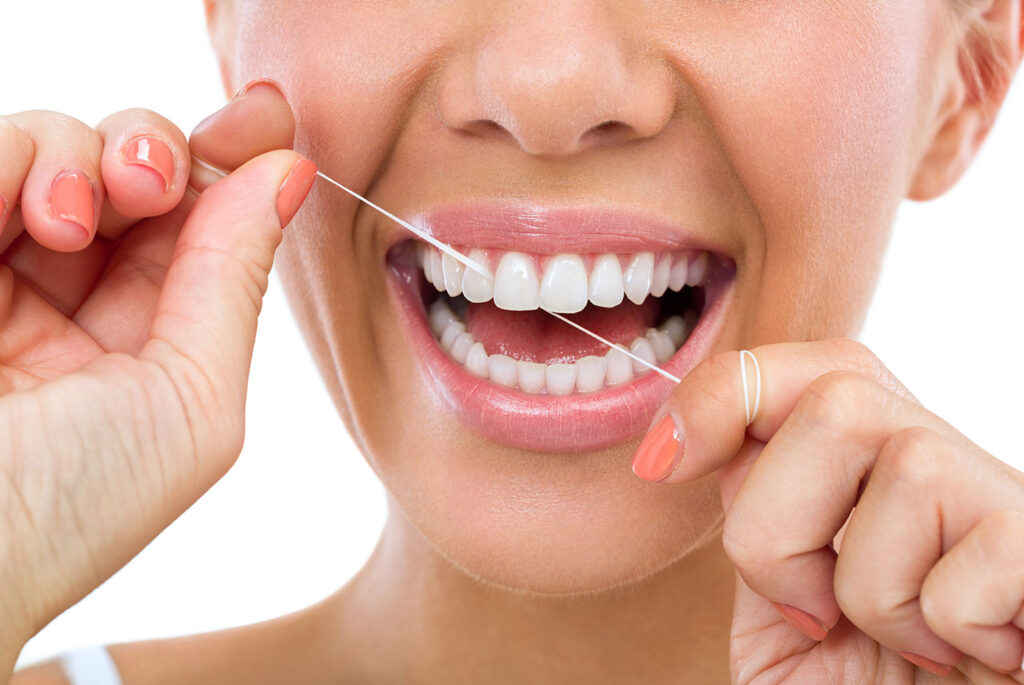 women flossing her teeth