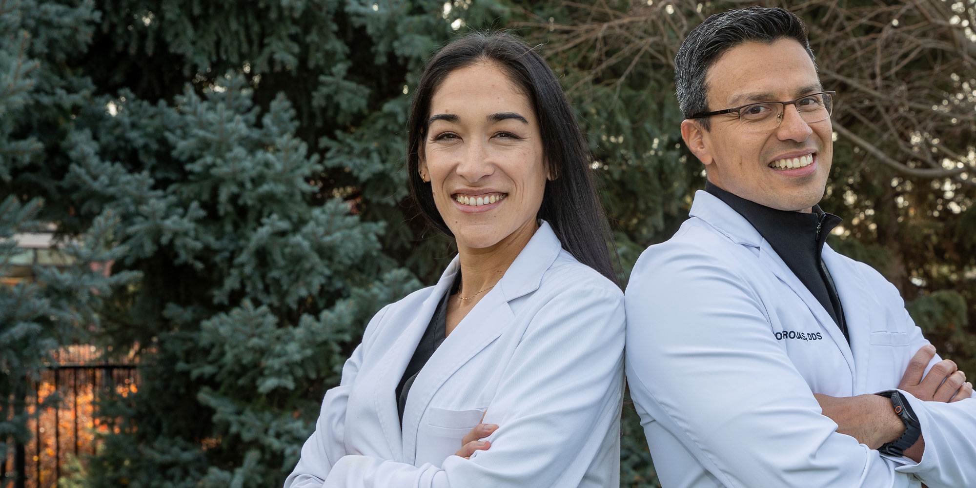 headshot of doctor posing and smiling outside fo the dental center